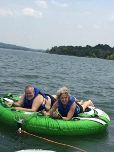 man and woman on o'brien tube on the lake